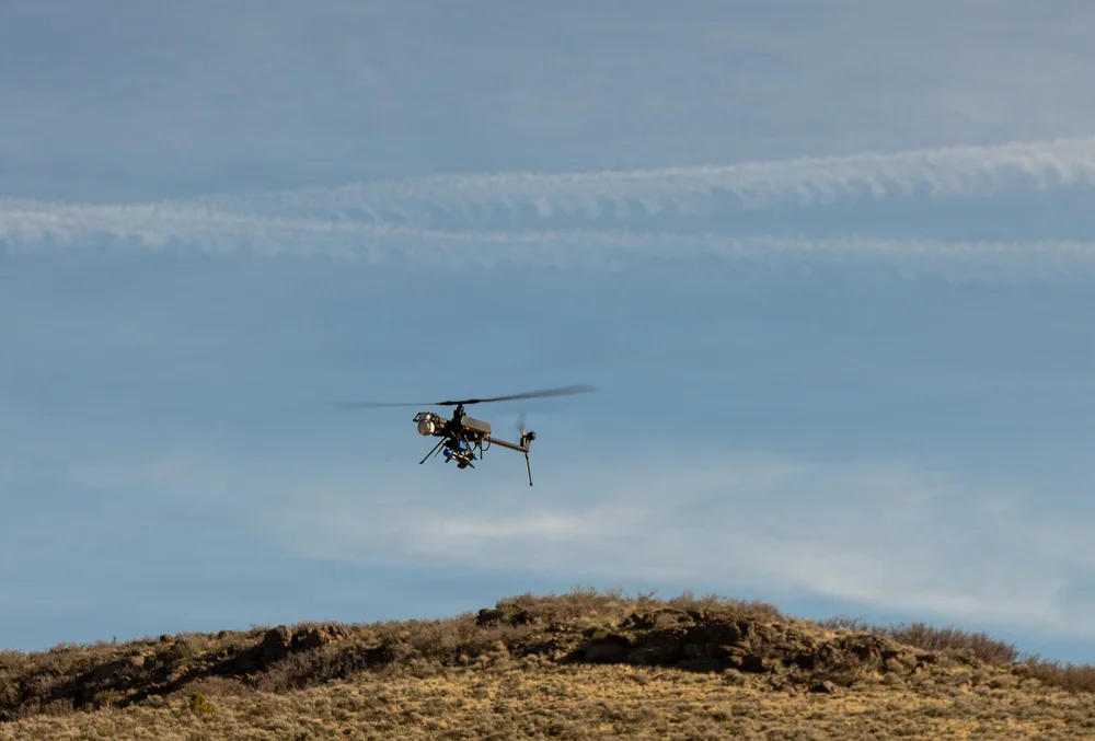 Compact unmanned helicopter flying above desert terrain